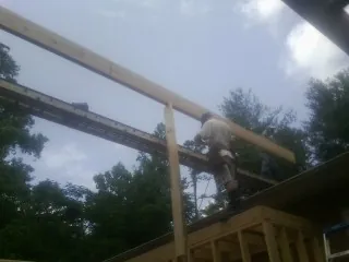 Carpenter setting a ridge beam over a new addition frame — Ice Dam Removal by Roofing Brothers in Ardsley