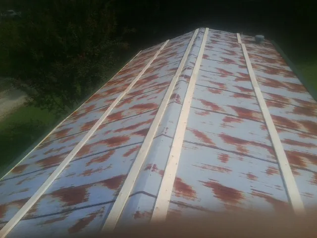Rusted metal roof panels with new wood purlins before replacement — Storm Damage Roof Repair in Ardsley by Roofing Brothers