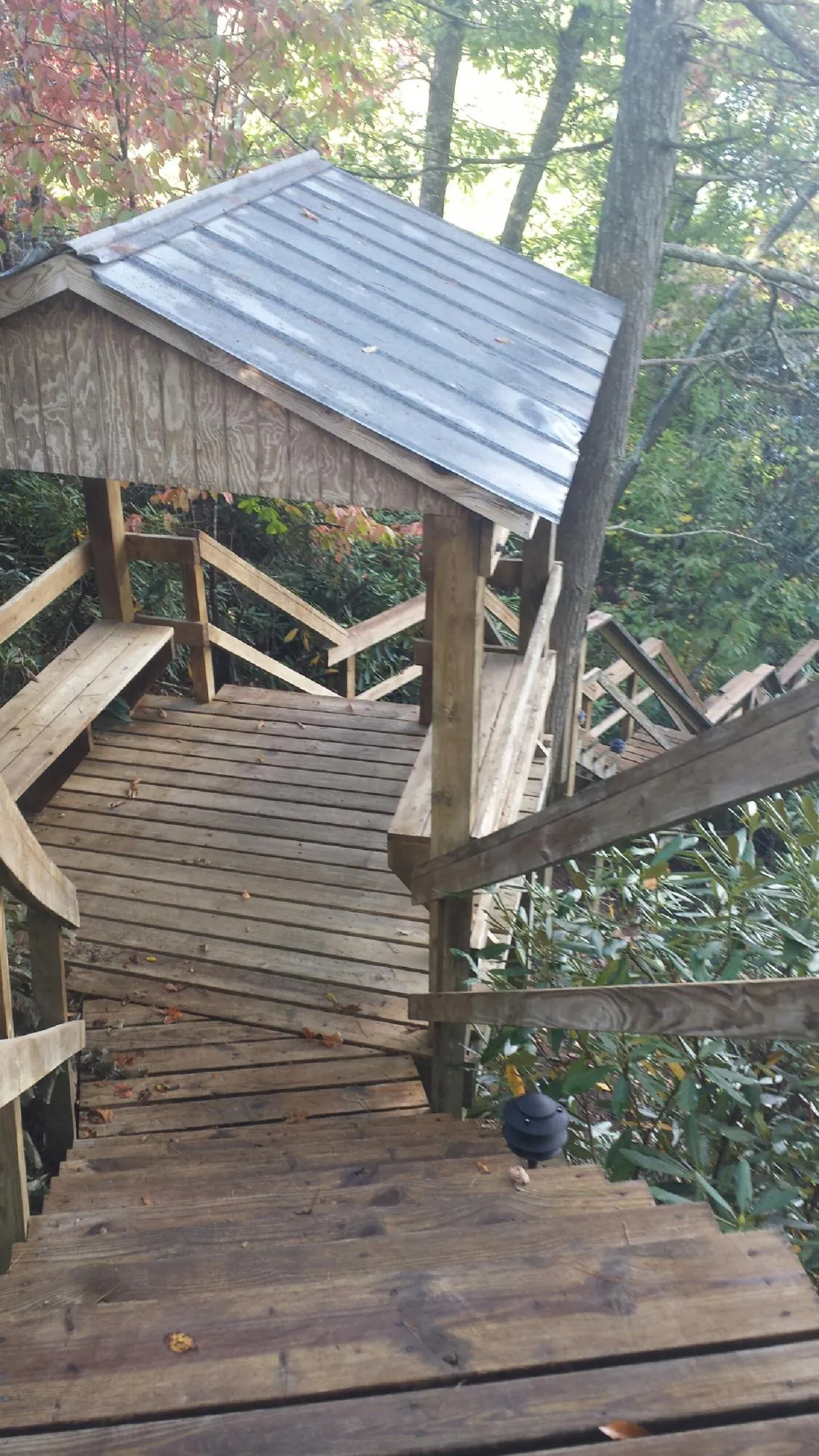 Metal roofed shelter over wooden steps on a wooded walkway — Skylight Repair & Installation work by our crew in Ardsley